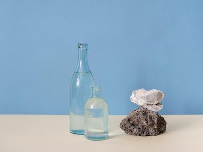 Glass water bottle on a clean wooden surface.
